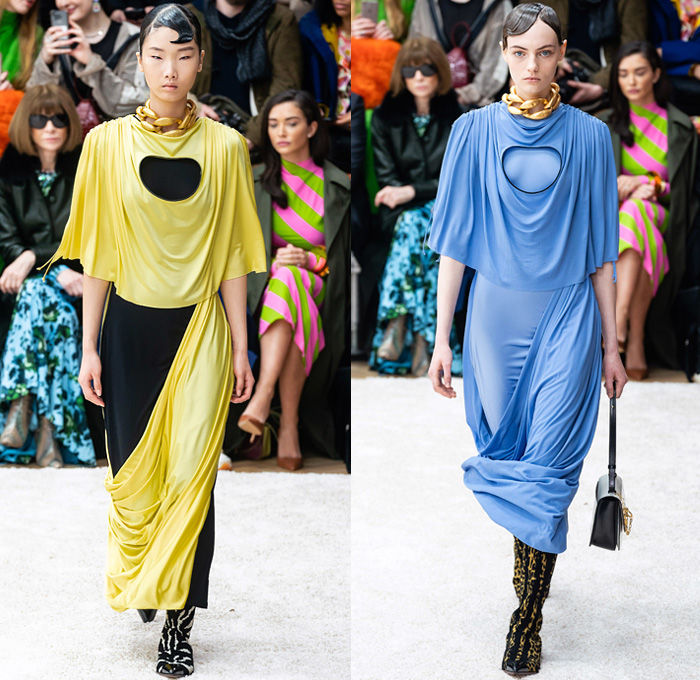 JW Anderson 2019-2020 Fall Autumn Winter Womens Runway Catwalk Looks - London Fashion Week Collections UK - Action Figure Doll Hair Oversized Wide Neckline Slouchy Sleeves Trench Coat Check Plaid Stripes Dots Sheer Tulle Cape Poncho Tie Up Waist Patchwork Blazer Pantsuit Lace Needlework Embroidery Houndstooth Tweed Paisley Knit Turtleneck Sweaterdress Hanging Sleeve Wide Leg Pants Belt Ruffles Bedazzled Silk Satin Dress Draped Fringes Gown Chain Equestrian Hat Bag Boots