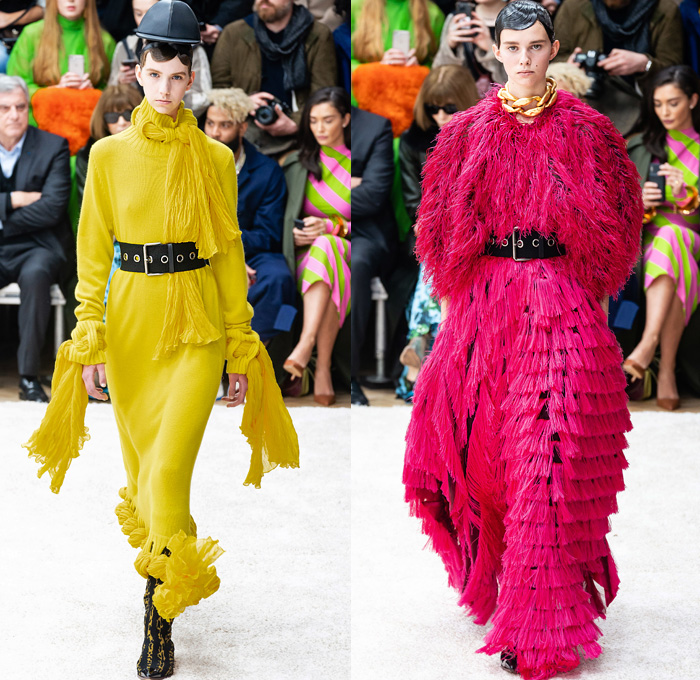 JW Anderson 2019-2020 Fall Autumn Winter Womens Runway Catwalk Looks - London Fashion Week Collections UK - Action Figure Doll Hair Oversized Wide Neckline Slouchy Sleeves Trench Coat Check Plaid Stripes Dots Sheer Tulle Cape Poncho Tie Up Waist Patchwork Blazer Pantsuit Lace Needlework Embroidery Houndstooth Tweed Paisley Knit Turtleneck Sweaterdress Hanging Sleeve Wide Leg Pants Belt Ruffles Bedazzled Silk Satin Dress Draped Fringes Gown Chain Equestrian Hat Bag Boots