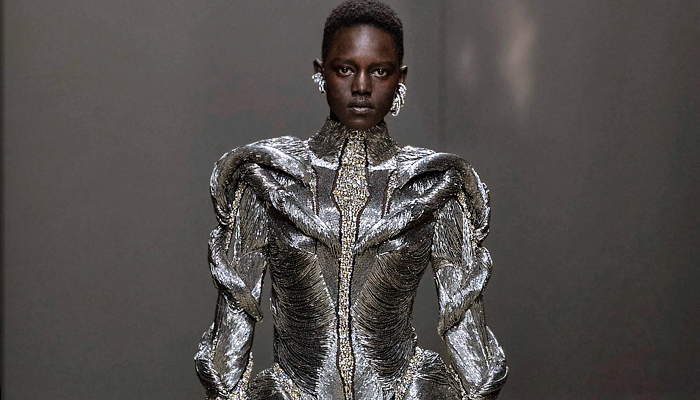 Alexander McQueen 2023-2024 Fall Autumn Winter Womens Runway Collection - Paris Fashion Week Femme PFW - Strapless Bustier Belts Motorcycle Biker Frankenstein Shoulders Metallic Fringes Bugle Beads Studs Crystals Embroidery Pantsuit Cutout Knit Ribbed Coils Sweater Turtleneck Black Corset Onesie Jumpsuit Skeletal Orchid Jacquard Nightshade Dress Exploded Neckline Sheer Tulle Pinstripe Gown Trench Coat Ruffles One Shoulder Denim Jeans Wrapped Puffball Skirt Shorts Boots Handbag Gloves