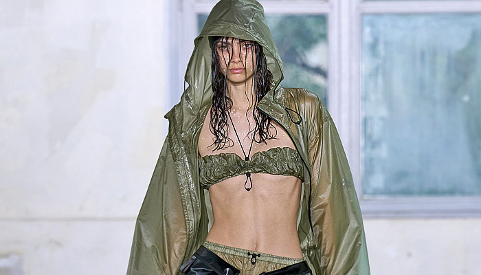 Rains 2024 Spring Summer Womens Runway Collection - Paris Fashion Week Homme Printemps Eté - Drenched Crop Top Midriff Bandeau Fringes Strings Drawstring Hood Outerwear Poncho Coat Anorak Shorts Raincoat Rainwear Parka Vest Crumpled Wrinkled Plastic Nylon Water-Repellent Waterproof Water-Resistant Cinch Leotard Sheer Dress Marbled Wide Leg Baggy Loose Palazzo Pants Fanny Pack Belt Bag Pouch Leg Warmers Puffer Sneakers