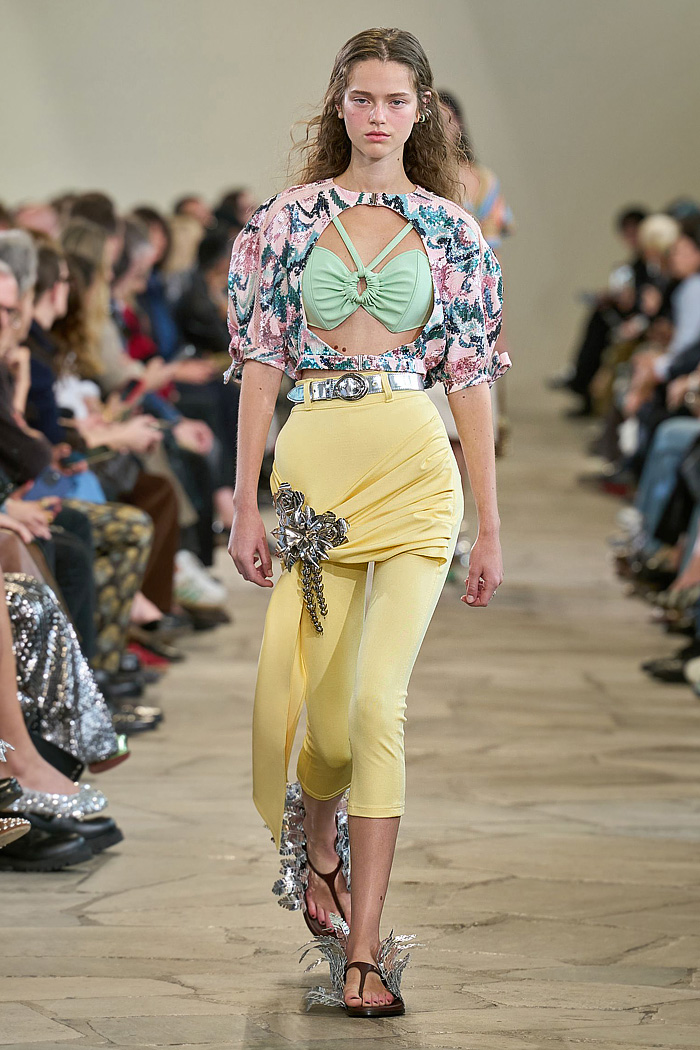 Paco Rabanne 2026 SS PFW: sequin cutout blouses, halterneck bikini tops, metallic foliage, floral miniskirts, capri leggings, oversized belts, crystal gems, bug-eye sunglasses, Paris runway.