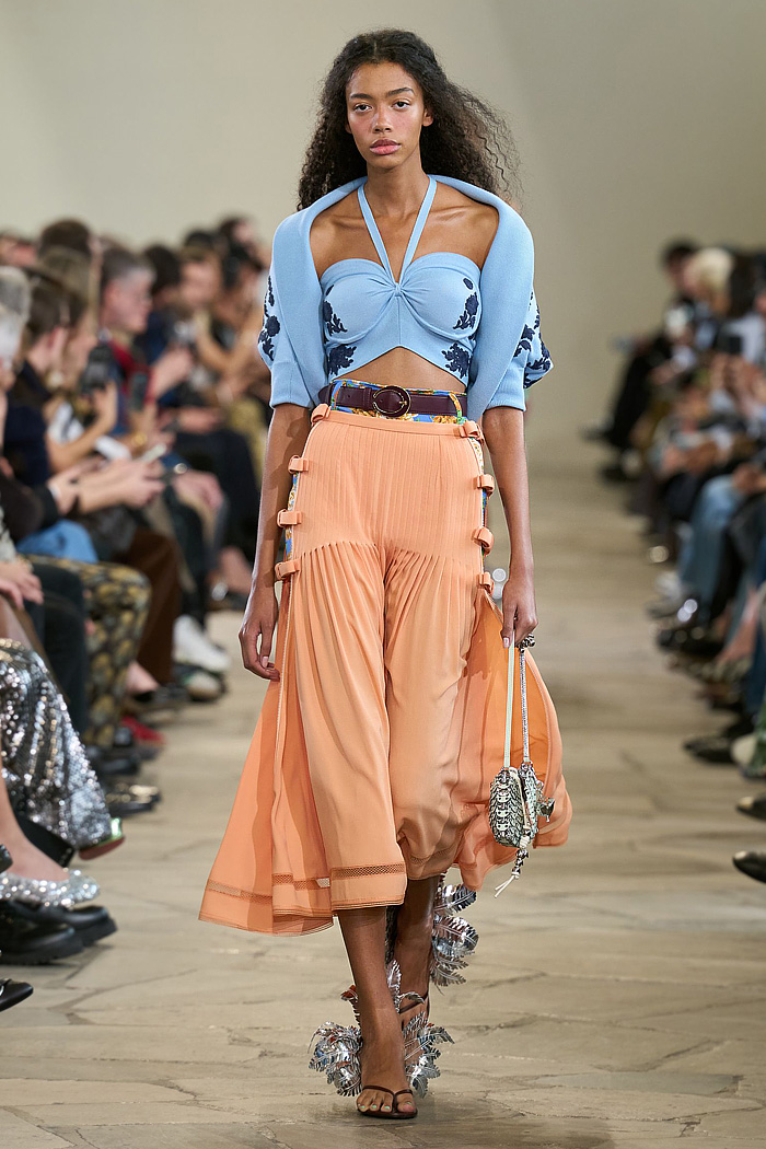 Paco Rabanne 2026 SS PFW: sequin cutout blouses, halterneck bikini tops, metallic foliage, floral miniskirts, capri leggings, oversized belts, crystal gems, bug-eye sunglasses, Paris runway.