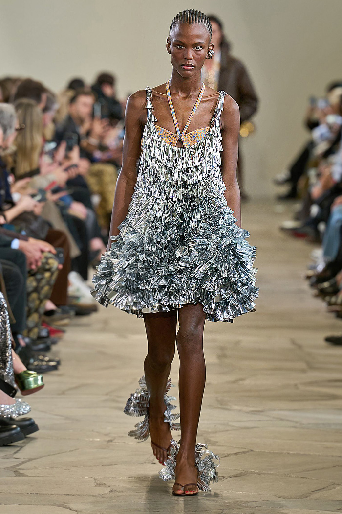 Paco Rabanne 2026 SS PFW: sequin cutout blouses, halterneck bikini tops, metallic foliage, floral miniskirts, capri leggings, oversized belts, crystal gems, bug-eye sunglasses, Paris runway.