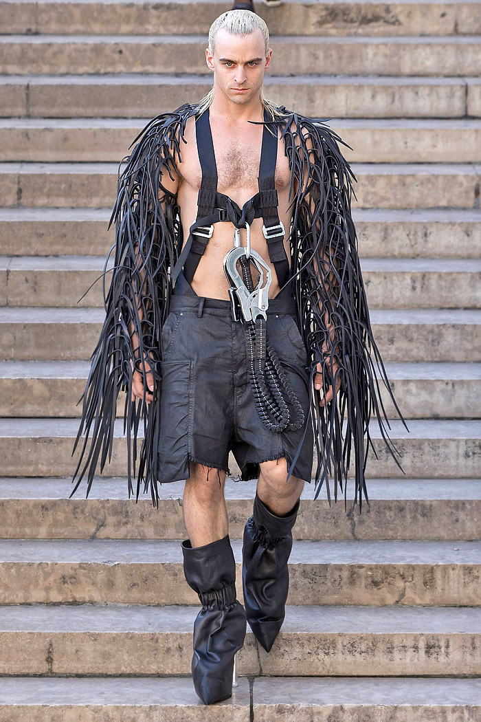 Rick Owens 2026 Spring Summer Mens: vest, sequins, tabard, studs, straps, crop jacket, biker, fringes, carabiner, wrapped boots