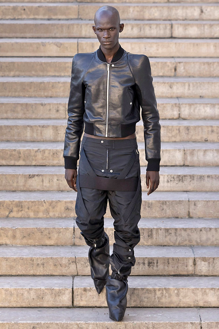 Rick Owens 2026 Spring Summer Mens: vest, sequins, tabard, studs, straps, crop jacket, biker, fringes, carabiner, wrapped boots